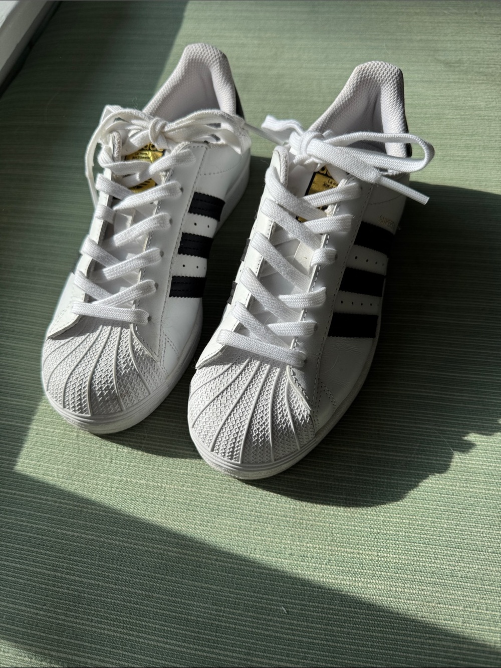 adidas White Sneakers with Black Stripes and Gold Tongue Detail